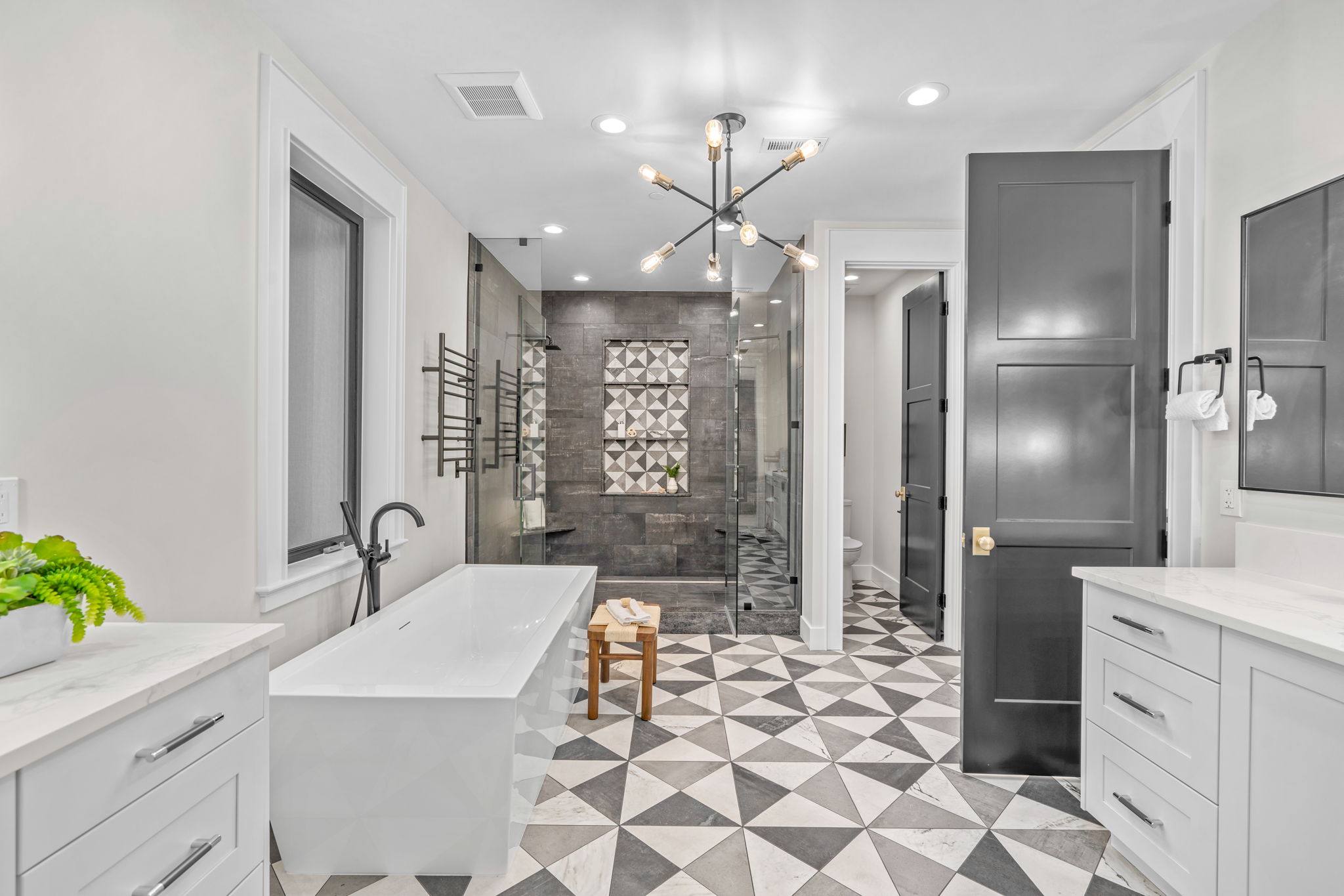 Primary bathroom remodel with geometric tile floor and freestanding soaking tub