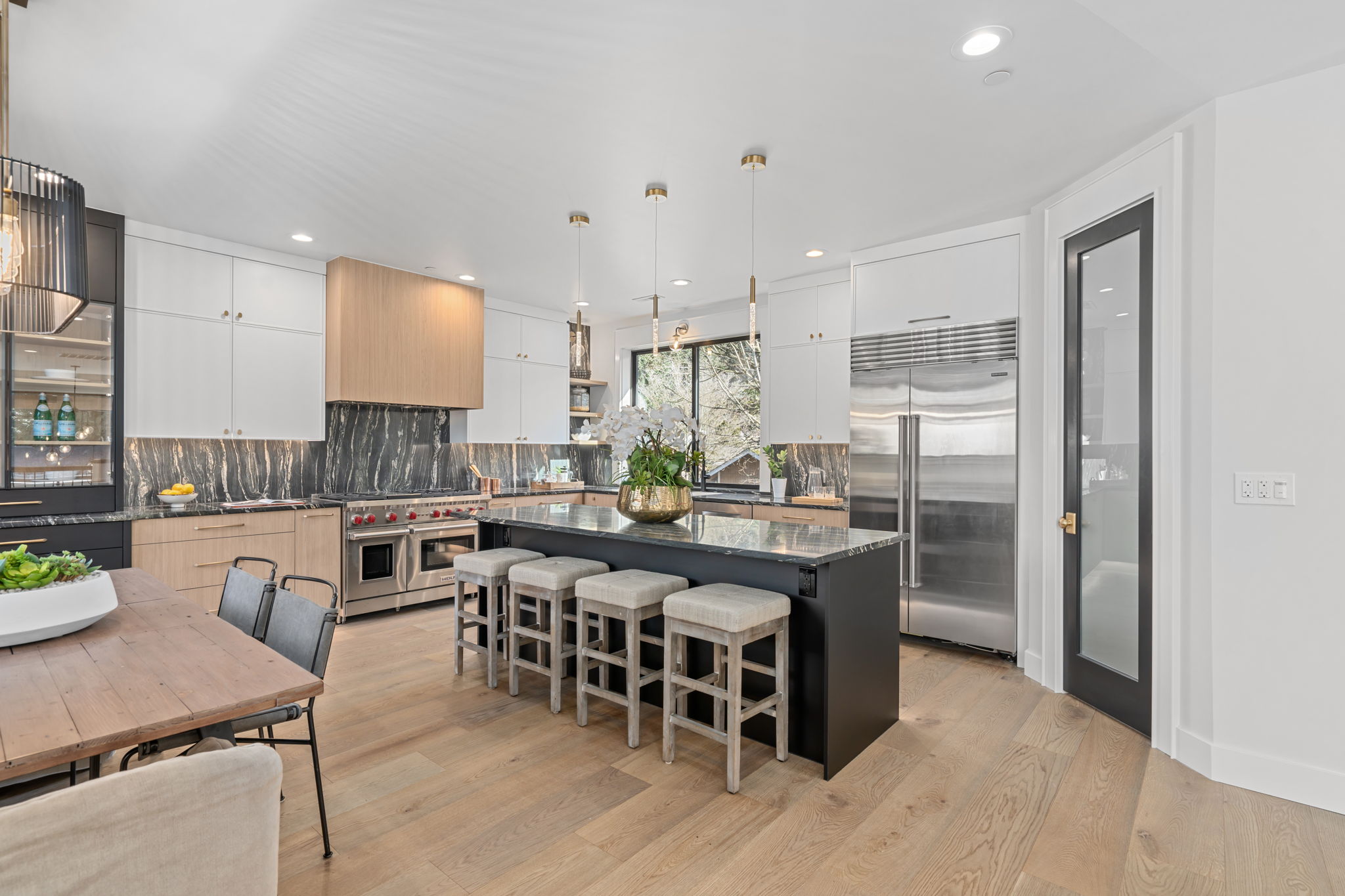 Bellevue kitchen remodel with marbled stone backsplash, waterfall island, and brass pendant lighting
